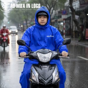 Người lái xe máy mặc áo mưa bít hông màu xanh dương vượt qua cơn mưa lớn an toàn