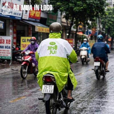 Logo Richy Jin Ju in lụa sắc nét ở mặt sau lưng áo mưa nổi bật khi di chuyển trên đường phố