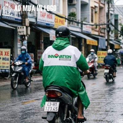 Góc nhìn từ phía sau người lái xe máy cho thấy logo thương hiệu in sắc nét và nổi bật trên dải vải trắng ngang lưng