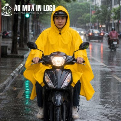Nam nhân viên mặc áo mưa cánh dơi màu vàng lái xe máy Honda Vision dưới trời mưa lớn tại Hà Nội.