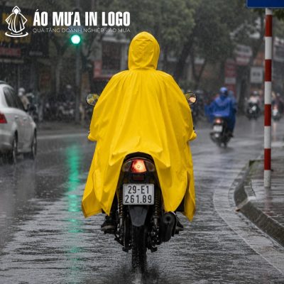 Góc nhìn từ phía sau của người lái xe máy mặc áo mưa màu vàng nổi bật trên đường phố mưa ướt.