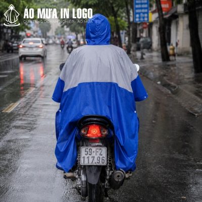 Góc chụp từ phía sau của áo mưa phối màu xám xanh khi di chuyển trên đường phố trong thời tiết mưa gió