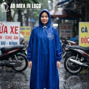 Nữ nhân viên mỉm cười nhẹ nhàng khi mặc áo mưa quà tặng từ công ty, một hình ảnh thân thiện và gần gũi trong ngày mưa tại Việt Nam.