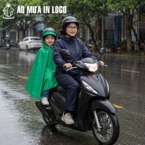 Bé trai mặc áo mưa poncho xanh lá ngồi an toàn phía sau xe máy của mẹ di chuyển trên phố mưa