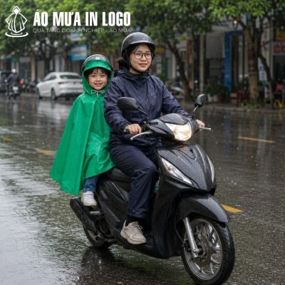 Bé trai mặc áo mưa poncho xanh lá ngồi an toàn phía sau xe máy của mẹ di chuyển trên phố mưa
