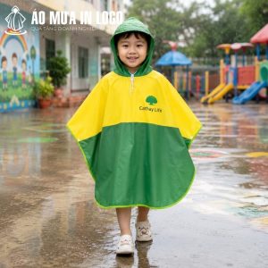 Bé trai mặc chiếc áo mưa poncho Cathay Life rạng rỡ trên sân trường ngày mưa