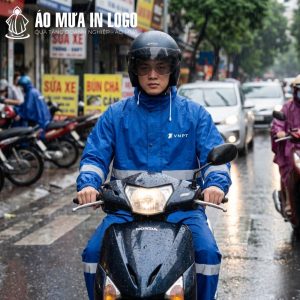 Người mẫu đội mũ bảo hiểm lái xe máy Honda dưới trời mưa trong bộ quần áo mưa VNPT